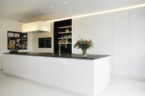 strakke witte keuken met zwart werkblad