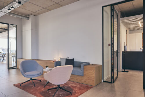 Een kantoor met stoelen en een glazen deur.