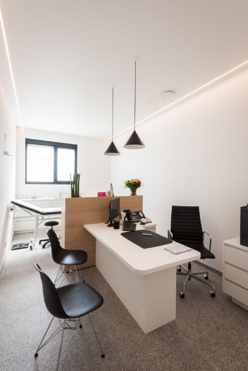 Een modern kantoor met strakke witte muren en stijlvol houten meubilair. Een perfecte mix van elegantie en functionaliteit.