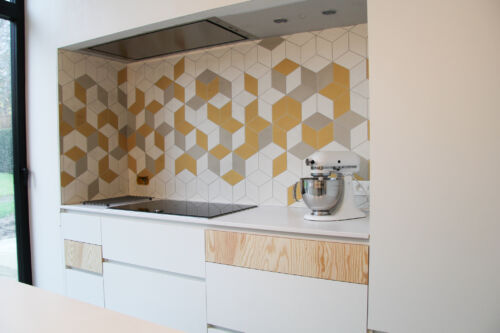 Elegante keuken met witte en gouden tegels.