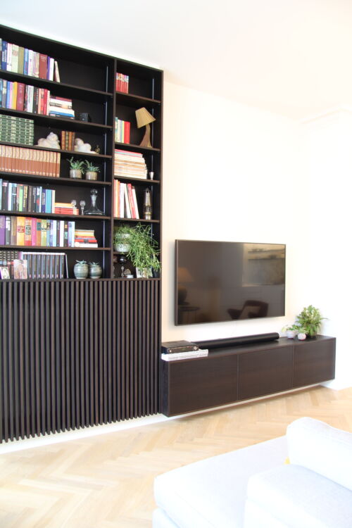Gezellige woonkamer met tv en boekenplanken.